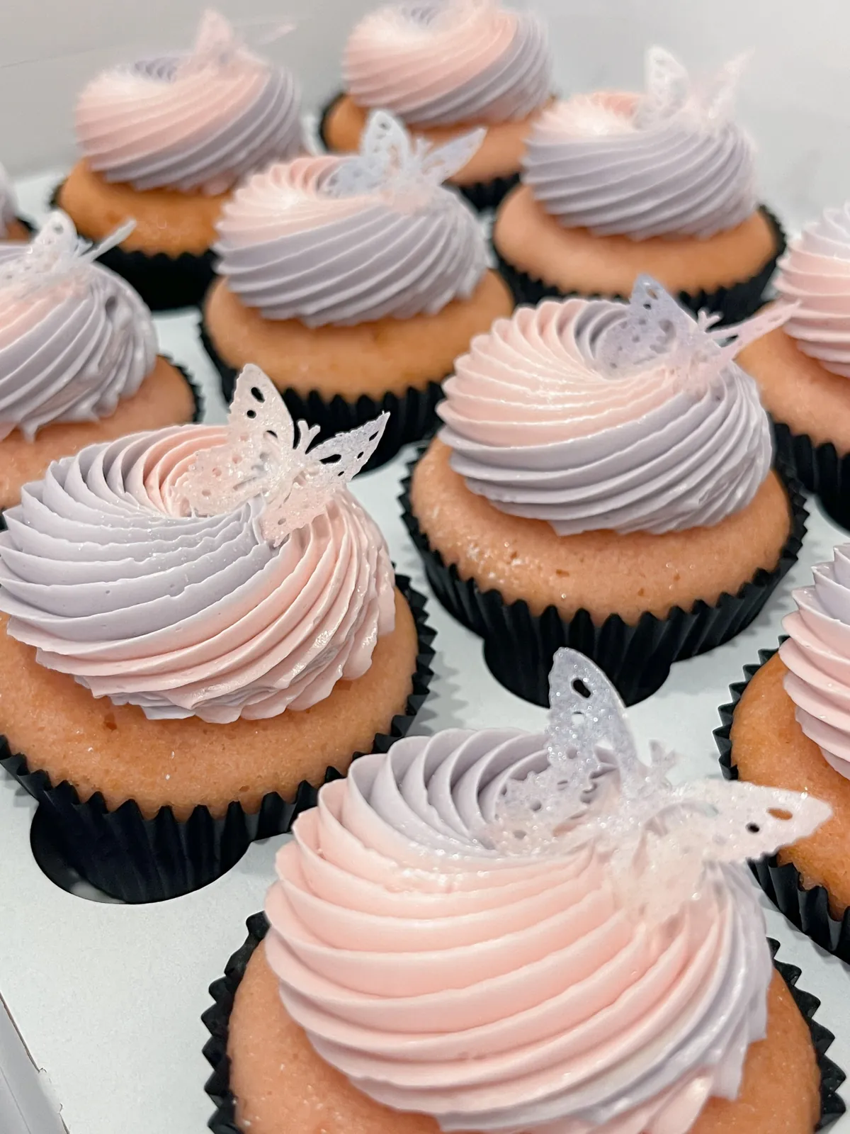 Pink and lilac buttercream cupcakes with butterfly decorations